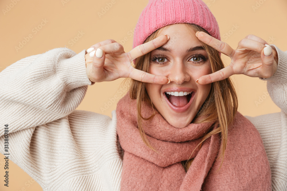 Poster Image of young girl in winter hat smiling and showing peace fingers