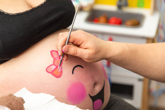baby belly of a pregnant woman is painted