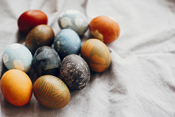 Stylish easter eggs on rustic table. Natural dyed colorful easter eggs  on rural linen textile background. Space for text.