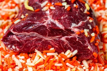 Raw beef meat in sliced vegetable.