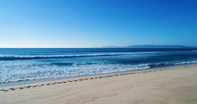 Slow motion of the beach and waves crashing at the Comporta Beach in Portugal.