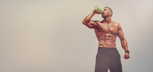 Nutritional Supplement. Muscular Men Drinks Protein, Energy Drink After Workout. Copy Space