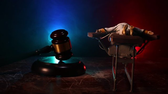 Lethal injection concept. Prisoner handcuffed to death by lethal injection. Creative artwork decoration with scale model on dark with lights.
