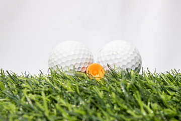 The golf ball is placed on a green artificial grass. It means getting ready to play golf