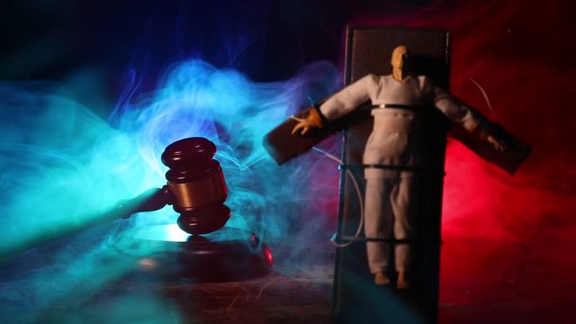 Lethal injection concept. Prisoner handcuffed to death by lethal injection. Creative artwork decoration with scale model on dark with lights.