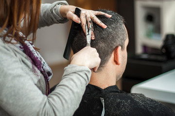 Peluquera cortando el pelo a hombre