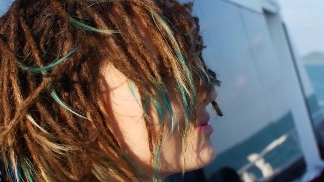 Strong wind ruffles the hair of a girl with dreadlocks