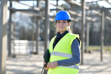 young woman apprentice standing on construction site