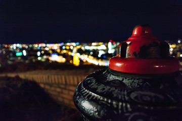 Hydrant vor einer Stadt bei Nacht