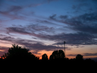 view over a beautiful sunset behind a radio antenna tower.