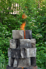 Fire flame in the brick fireplace in the garden.