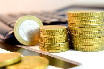 Monedas de euro apiladas, de fondo calculadora