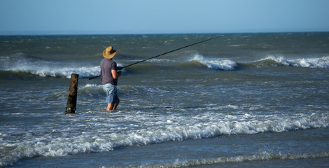man with Fishing rod on beach