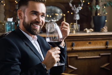 Handsome bearded man with a glass of red wine