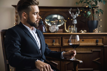 Handsome bearded man with a glass of red wine