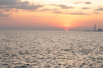 The red sun over the evening sea near the industrial area by the sea