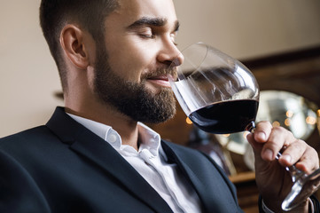 Handsome bearded man with a glass of red wine