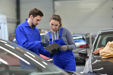 Apprentice in car industry using digital tablet