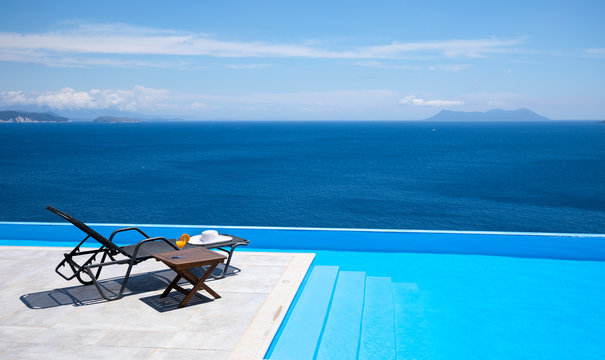 Infinity pool with chairs and table With a view of the sea 