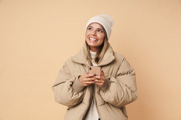 Portrait of happy young woman laughing and using cellphone