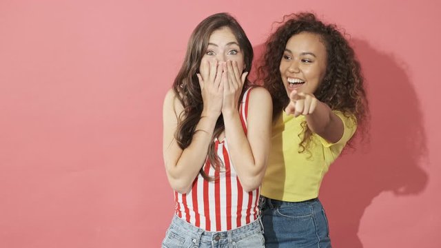 Happy pretty curly woman making surprise for her friend over pink background
