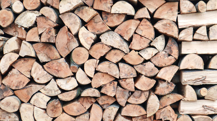 A neatly folded log of chopped wood. The fire is melting. Firewood stacked on top of each other. Firewood is collected for heating in cold weather. Background texture of stacked dry firewoods