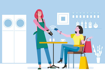 Woman paying contactless with credit card to a felmale waiter