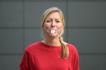 Middle-aged blond woman chewing gum