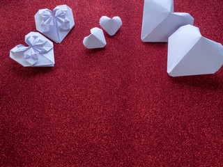Origami paper hearts shape symbols for Valentines Day, With gift ribbon with red hearts. Copy space...