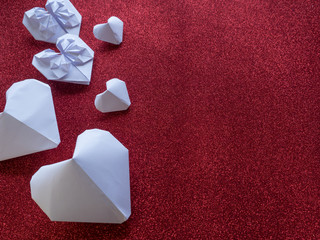 Origami paper hearts shape symbols for Valentines Day, With gift ribbon with red hearts. Copy space for text or design
