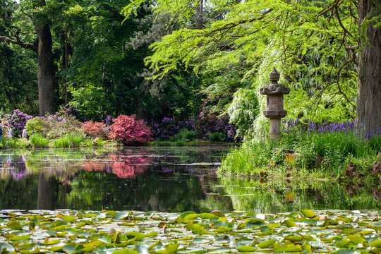 .Stone lantern from Asia on an island with blooming rhododendrons in the background