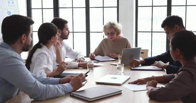 Serious mature company ceo talk at diverse group board meeting