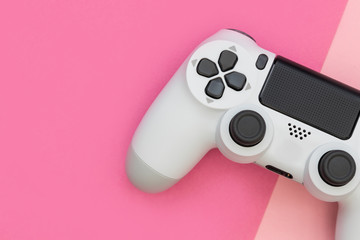 Video game gaming controller on pink color background top view