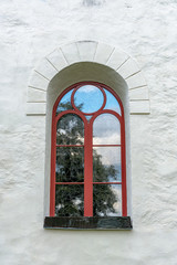 Vaulted window with red frame and glazing bars