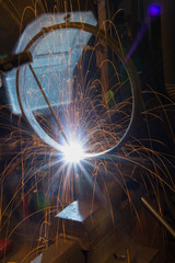 metal worker welds a ring of steel
