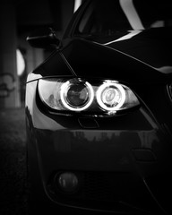 Front headlights of BMW car. Black and white content. Great wallpaper for bmw lovers - obrazy, fototapety, plakaty