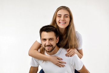 Fototapeta premium beautiful happy couple in love are hugging and looking at camera on white background. st valentines day