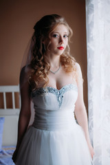 Fototapeta premium Portrait of a bride in a white dress with red lips