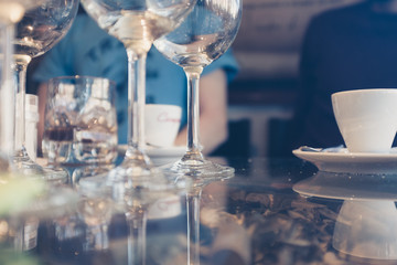 Glass cup with ice cubes and coffee on a glass table 
