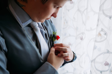 Young groom in a suit of gray tones