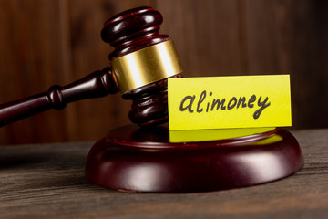 Pile of dollars with word alimony on a stick