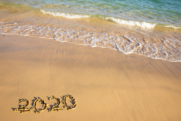 2020 summer beach holiday season written on golden sand washed away wave - new season lettering on sand - numbers 2020 year travel vacation sandy wavy water yellow blue azure aquamarine turquoise