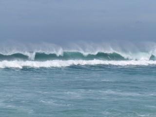 Summer morning at the beach with high tide and high winds.