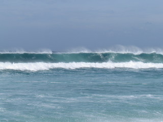 Summer morning at the beach with high tide and high winds.