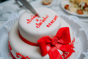 cake with ribbon and bow on red background