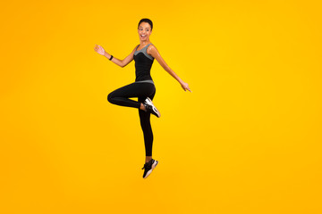 Fototapeta na wymiar Afro Lady Jumping Exercising In Studio On Yellow Background