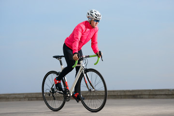Young Woman Riding Road Bicycle on Free Road in the City. Healthy Lifestyle and Sport Concept.