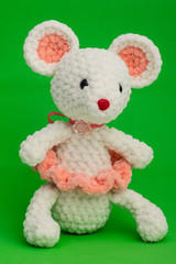 Knitted toy mouse on a green background