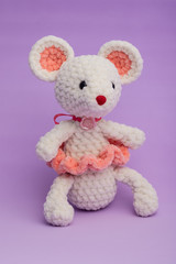 Knitted with his hands toy mouse on a lilac background