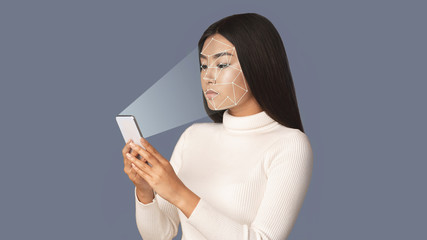 Biometric verification. Girl with smartphone using face ID